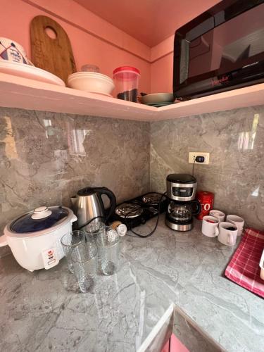 a kitchen with a counter top with a stove and a microwave at Cara Transient house in San Pablo