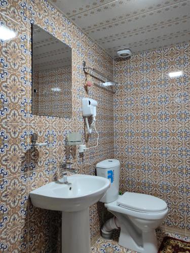 a bathroom with a sink and a toilet and a mirror at Darvozai Samarkand guest house in Samarkand