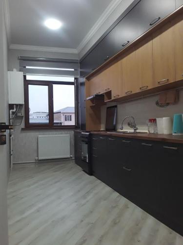 une grande cuisine avec un évier et une fenêtre dans l'établissement Apartment, à Ferghana