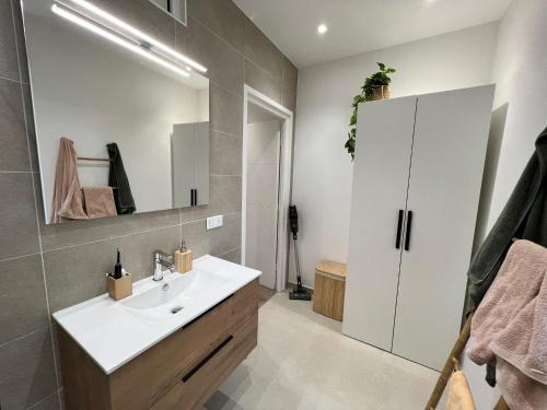 uma casa de banho com um lavatório branco e um espelho. em Le Riquier - Port de Nice em Nice