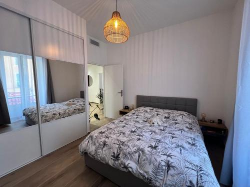 1 dormitorio con cama y espejo en Le Riquier - Port de Nice, en Niza