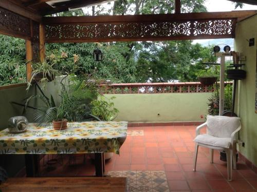 eine Terrasse mit einem Tisch und einem weißen Stuhl in der Unterkunft Apartamento-Galería de arte Cielo y Tierra in Medellín