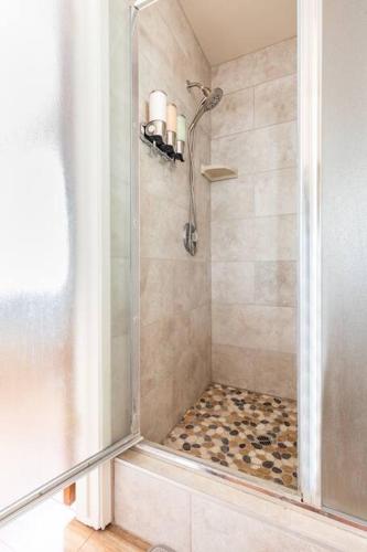 a shower with a glass door in a bathroom at Ponderosa Creekside Retreat in Mariposa