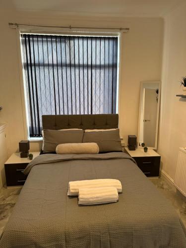 a bedroom with a large bed with two towels on it at Short Stayzzz in Manchester