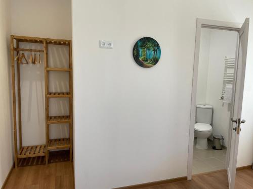 a bathroom with a toilet and a clock on the wall at Friendly Home in Tʼelavi