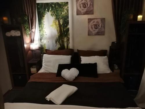 a bedroom with a large bed with a heart shaped pillow at Het Huisje in Bergen op Zoom