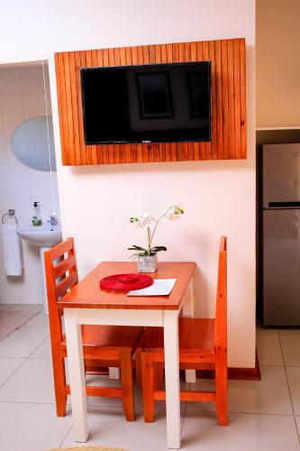 a kitchen with a table with chairs and a microwave at Olive Country Lodge - Eswatini in Ngwempisi
