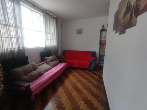 a living room with a couch and a red chair at Hostel Maktub in Sao Paulo