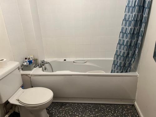 a bathroom with a toilet and a bath tub with a toilet at Room in the centre of Portsmouth in Portsmouth