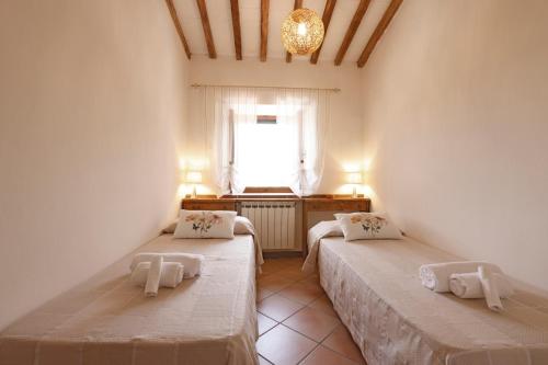 two beds in a room with a window at Agriturismo Casale le Crete in Acquapendente