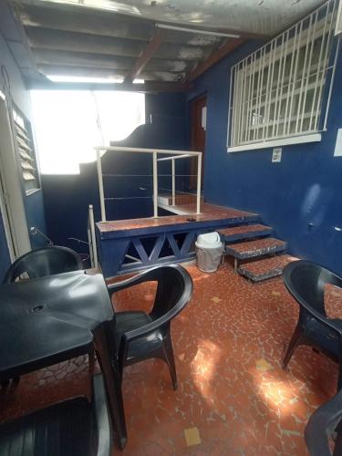 a room with chairs and a table and stairs at Hostel Maktub in Sao Paulo
