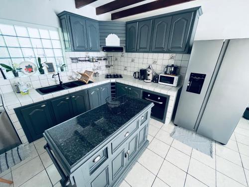 a kitchen with green cabinets and a refrigerator at Villa Longani Passion pour des vacances bucoliques en famille in Petite Île