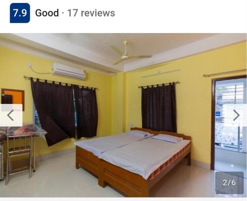 a bedroom with a bed with yellow walls and a window at Om niwas in Siliguri