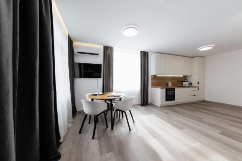 uma sala de estar com mesa e cadeiras e uma cozinha em Luxury Apartments CITY em Uzhhorod