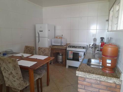a kitchen with a table and a stove and a refrigerator at Apartamento Inconfidência Diamantina in Diamantina