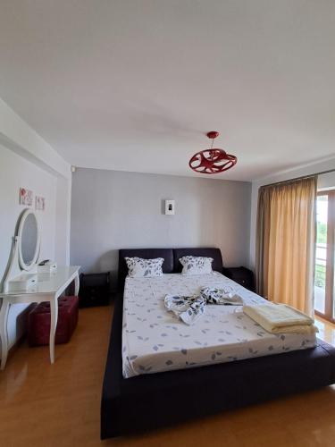 a bedroom with a bed and a table and a mirror at Casa verde 2 in Pantelimon