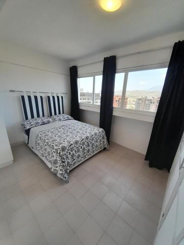 a bedroom with a bed and a large window at Executive Style Condo With Sea Views in Porlamar
