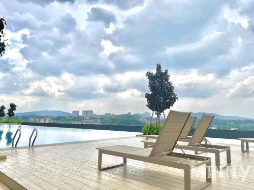 two lounge chairs sitting on the edge of a swimming pool at Netizen Balcony View MRT 4-5pax #17 in Cheras