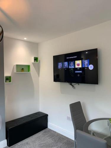 a room with a tv on a wall with a glass table at NEC/Airport - The Allium, Two bedroom apartment in Marston Green
