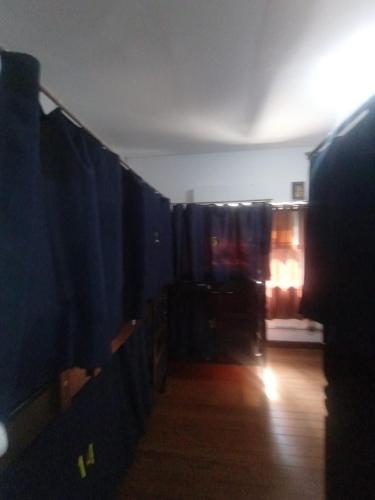 a room with blue curtains and a wooden floor at Hostel Maktub in Sao Paulo