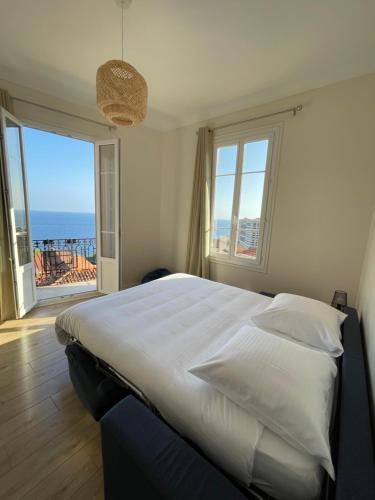 a bedroom with a bed with a view of the ocean at 2 pièces BeHappy next Monaco in Roquebrune-Cap-Martin