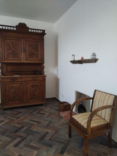 a room with a wooden cabinet and a chair at Domus Al.Me in Castelmezzano