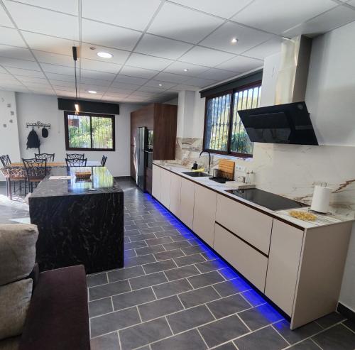 une grande cuisine avec des armoires blanches et des comptoirs noirs dans l'établissement Casa Rural Sierra de las Nieves 2, à Tolox