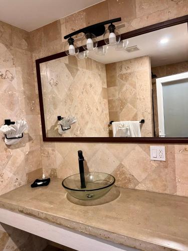 a bathroom counter with a sink in front of a mirror at The Watermark Hotel in San Pedro