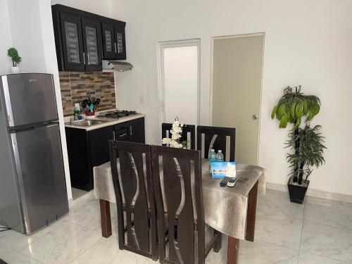 uma cozinha com uma mesa e cadeiras e um frigorífico em Departamentos Villa 112 em Mazatlán