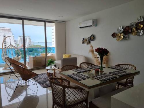 a living room with a table and chairs with a view at Sensacional apartamento en Samaria Club de Playa in Santa Marta