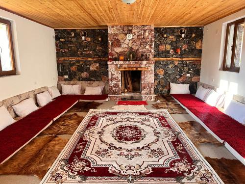 a large living room with a fireplace and a rug at Guesthouse Kevin in Kukës