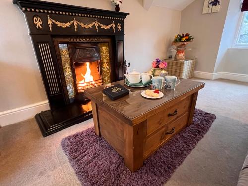 a living room with a fireplace and a coffee table at Windermere Boutique Hotel Spa Suites & Hot Tubs in Windermere