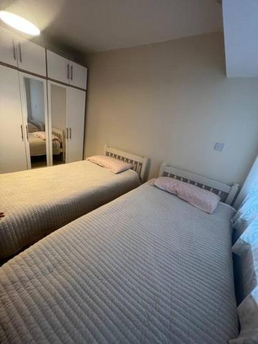 a bedroom with two beds and a mirror at Solihull house weekly/ monthly in Sheldon