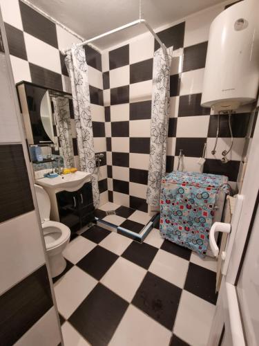 a bathroom with a black and white checkered floor at Kirkovski apartment in Skopje