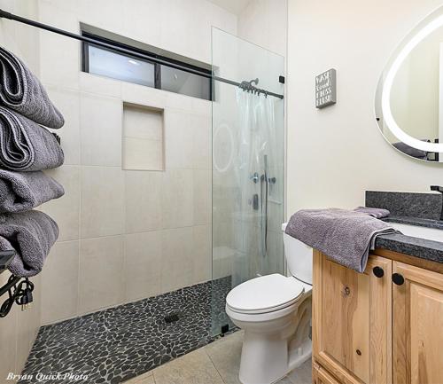 a bathroom with a shower and a toilet and a sink at Three Bedroom River Access in Redding