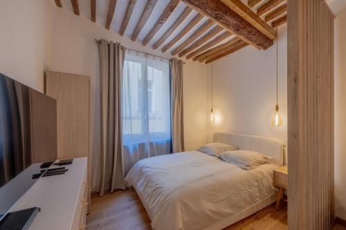 une chambre avec un lit et une grande fenêtre dans l'établissement Appartement de charme, à Aix-en-Provence