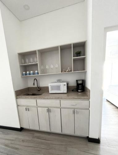 a kitchen with a sink and a microwave at The Watermark Hotel in San Pedro
