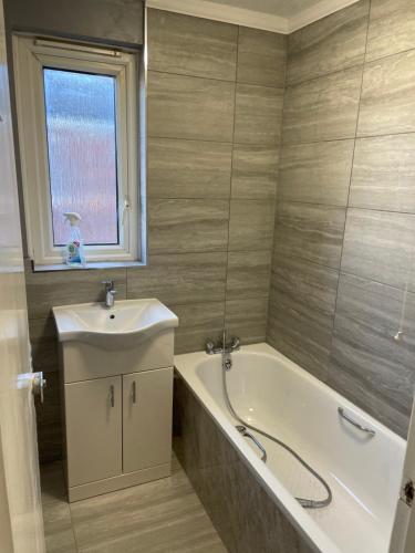 a bathroom with a tub and a sink and a bath tub at Modern big 2 bedroom in Northolt with terrace parking in Northolt