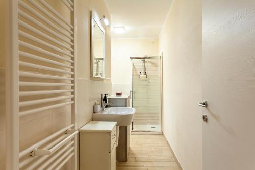Baño blanco con lavabo y espejo en Veruskacamere Camera 2 en Somma Lombardo