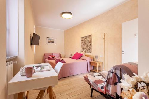 ソンマ・ロンバルドにあるVeruskacamere Camera 2のベッド2台とテーブルが備わる小さな客室です。