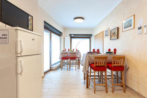 a kitchen with a table and chairs and a refrigerator at Veruskacamere Camera 2 in Somma Lombardo