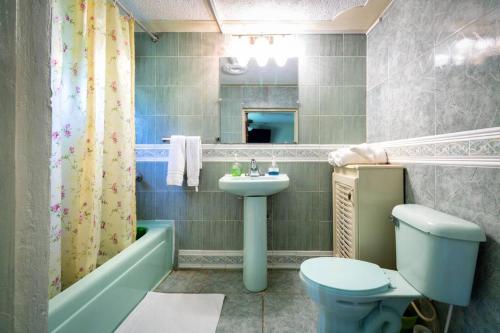 a bathroom with a sink and a toilet and a tub at Cozy Locale Pearl in Port Antonio
