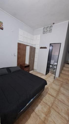 a bedroom with a black bed and a wooden floor at Alquiler por día- Zona Centro in San Fernando del Valle de Catamarca