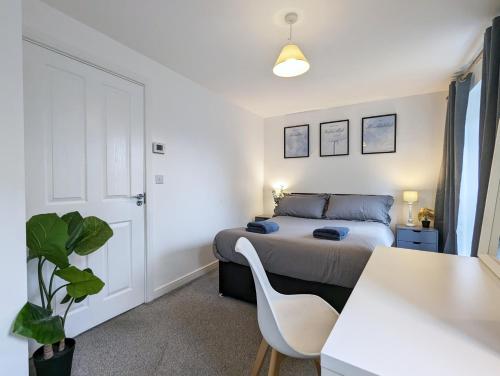 Guest Rooms Near City Centre & Anfield Free Parki في ليفربول: غرفة نوم بسرير وطاولة مع كرسي