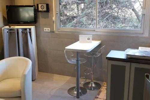 Cette chambre comprend une table, une télévision et un tabouret. dans l'établissement Studio Croisette, à Cannes