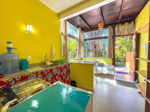 une cuisine jaune avec un évier et une fenêtre dans l'établissement Barra Quintal Studio 3, à Barra Grande