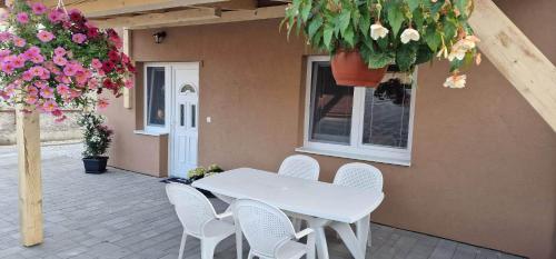 a white table and chairs on a patio with flowers at Andrea ubytovanie in Štúrovo