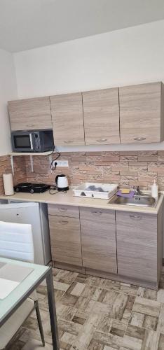 a kitchen with a sink and a microwave at Andrea ubytovanie in Štúrovo