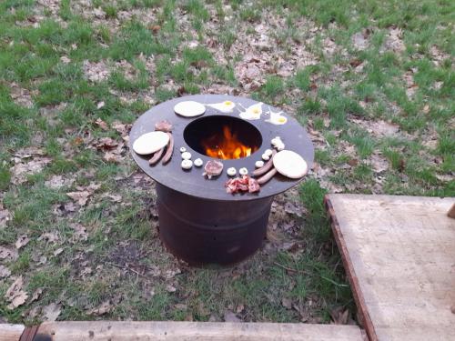 a barbecue cooker with a fire in the grass at Kromven On Wheels in Merksplas
