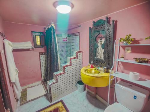 un bagno rosa con lavandino giallo e doccia di Ryad Zahrat Fes a Fes